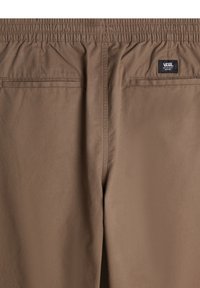 Brown trousers with elastic waistband, rear pockets, and VANS logo tag. Smooth texture and minimal seams, designed for comfort and practicality.