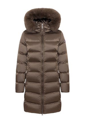 Brown long puffer coat with horizontal quilting, full front zipper, attached hood with thick faux fur trim, and logo patch on the left sleeve.