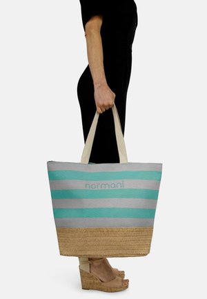 Gestreifte Tragetasche aus teal- und graufarbenem Stoff, mit einer geflochtenen Strohbasis und stabilen beigegriffen. Mit "normani"-Logo auf der Vorderseite.