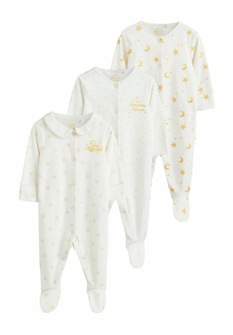 Drei weiße Babykombi aus weichem Stoff. Jede verfügt über goldene Sterne und Monde, wobei eine einen Kragen und gestickten Text hat.