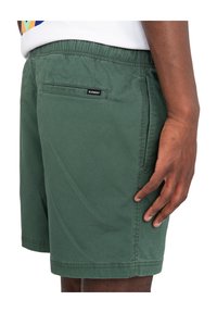 Pantaloni corti verde scuro in cotone, con vita elasticizzata, tasca laterale e un piccolo etichetta logo sulla tasca posteriore.
