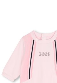 Robe en coton rose avec un col rond, des manches longues et un détail rayé contrastant avec le logo "BOSS" brodé sur le devant.