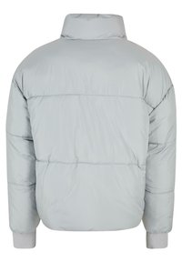 Lys grå pufferjakke med høy krage, ribbede mansjetter og quiltet design. Har en glatt, blank tekstur med en oversized passform.