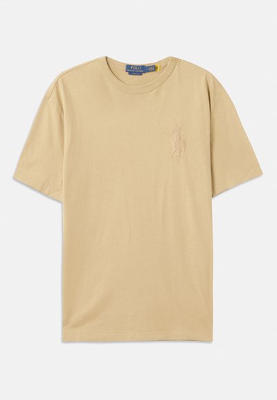 T-shirt de algodão bege com decote redondo, mangas curtas e um logótipo bordado no peito. Textura suave, corte clássico.
