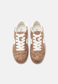 Καφέ αθλητικά παπούτσια με λευκά κορδόνια και λεπτομέρειες. Υφασμάτινο πάνω μέρος με σχεδιασμό με κουκκίδες, στρογγυλεμένη μύτη και ελαστική σόλα.