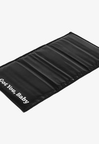 Černá polstrovaná podložka se čtyřmi vodorovnými sekcemi, na jedné straně bílý nápis "Got You, Baby". Hladká textura a obdélníkový tvar.