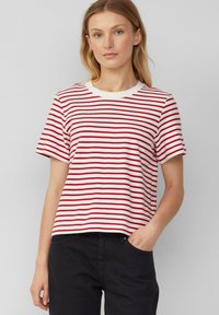 T-shirt rayé rouge et blanc avec un col rond et des manches courtes, fabriqué en tissu doux, possédant une coupe décontractée et sans motifs ni accents visibles.
