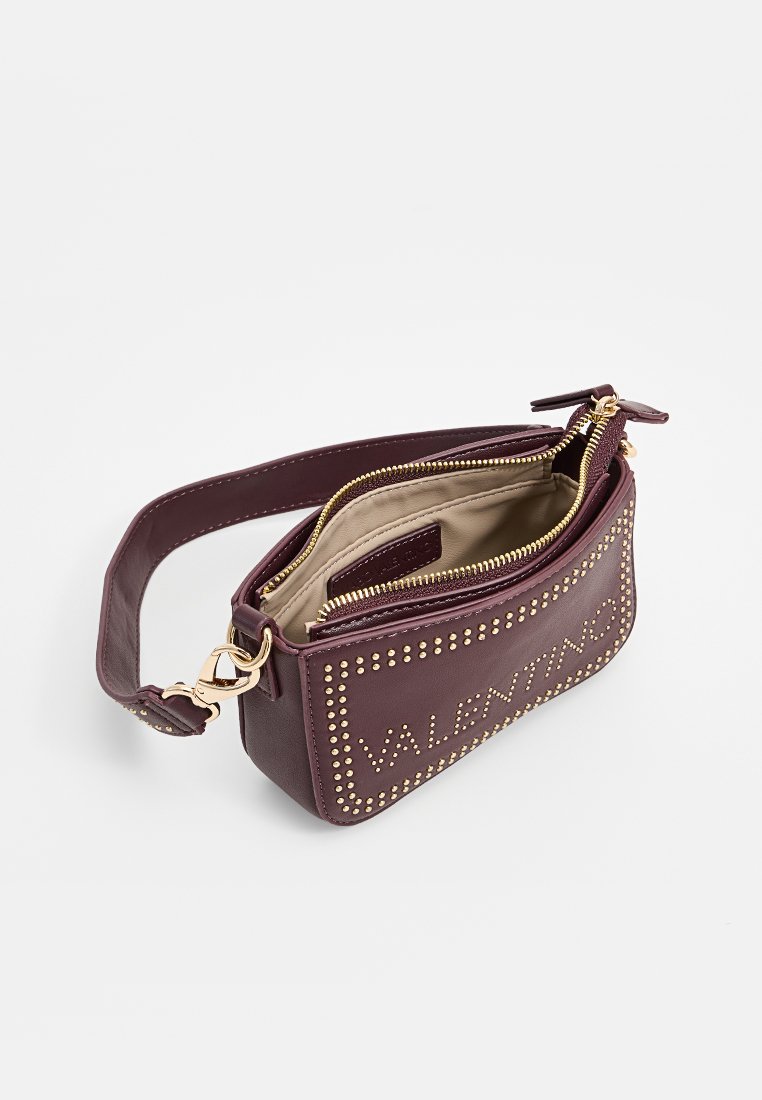 Bordeauxfarbene Ledertasche mit goldenen Nietenverzierungen, doppeltem Reißverschluss, verstellbarem Tragegurt und einem glatten Innenfutter.