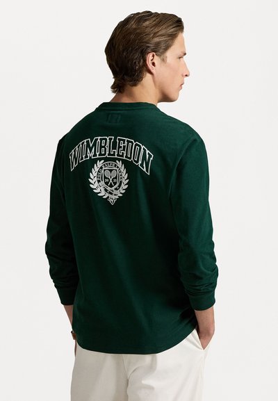 Donkergroene t-shirt met lange mouwen met een witte "Wimbledon" afdruk en een logo met rackets en laurier op de achterkant. Van katoen.