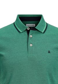 Grøn polo skjorte med struktureret stof, en kontrastfyldt sort krave og tre knapper. Mærket "JACK & JONES" er synligt på mærket.