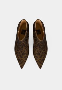 Botas de tobillo de estampado de leopardo con punta afilada y textura suave. El diseño presenta un ligero brillo y una paleta de colores en marrón y negro.