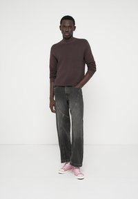 Σκούρο γκρι παντελόνι σε άνετη εφαρμογή με αντίθετη ραφή, συνδυασμένο με μια υφασμάτινη μακρυμάνικη μπλούζα σε μπόρντο απόχρωση και ροζ καμβαρέ αθλητικά παπούτσια.