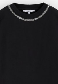 Sudadera negra con cuello redondo adornado con una decoración metálica de cristales a lo largo del cuello. Textura de tela suave, diseño casual.