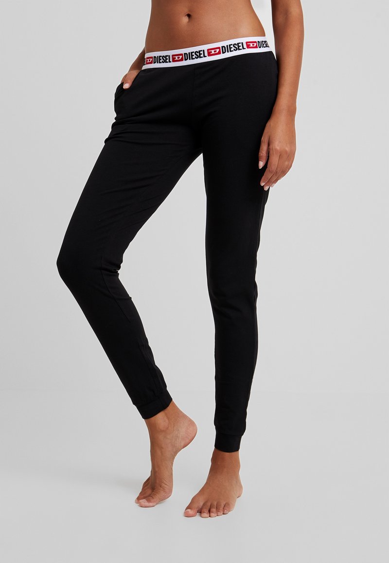 Schwarze Baumwoll-Jogginghosen mit einem elastischen Bund, der ein rotes und weißes Diesel-Logo zeigt. Schmal zulaufende Passform, weiche Textur und Bündchen an den Knöcheln.
