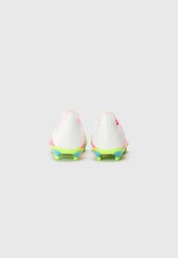 Witte voetbalschoenen met roze accenten, textuurmateriaal en felgroene noppen op de buitenzool. Achteraanzicht toont de gebogen vorm en details van de hak.