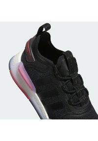 Black athletic shoe with mesh upper, tonal three-stripe logo, and a gradient sole featuring red and white accents. Textured lacing system.