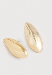 Goldfarbene glatte ovale Ohrstecker mit einer reflektierenden gewölbten Oberfläche auf einem weißen Hintergrund.