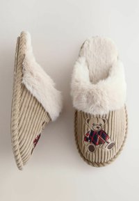 Beige corduroy slippers with a plush faux fur cuff, featuring a teddy bear embroidery in a checkered pattern on one side.