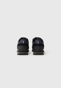 Black and navy athletic shoes with a mesh upper, padded collar, and textured outsole, featuring a reinforced heel and contrasting accents.