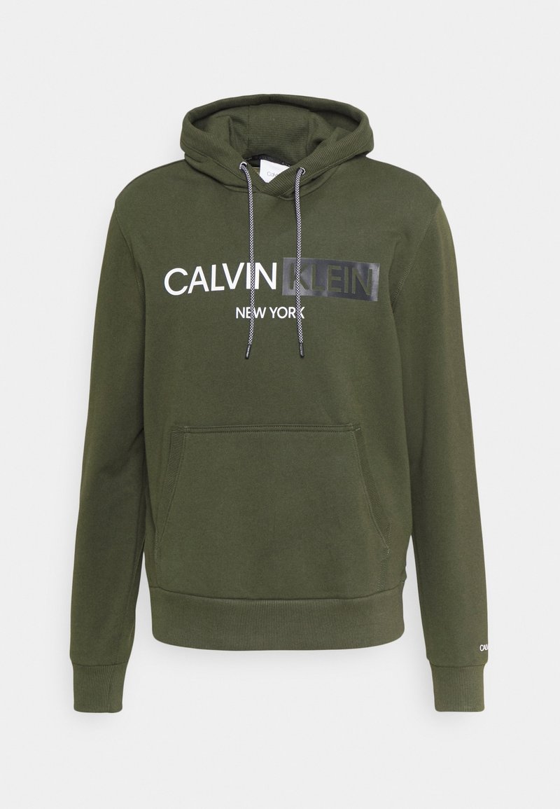 Sweat à capuche vert olive avec poche avant, cordons noirs et blancs, et logo "Calvin Klein New York" sur la poitrine.