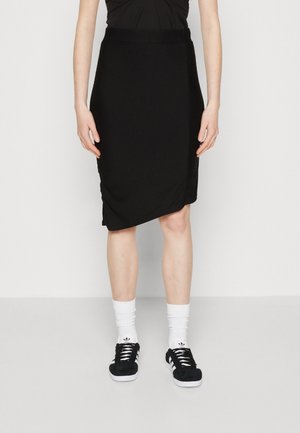 Must muströölistega must seelik, millel on voogav disain, põlvini, koos valgete sokkide ja mustade tossudega, millel on kolm triipu.