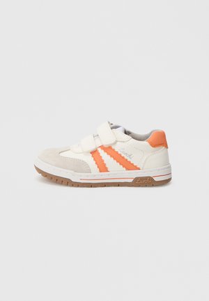 Chaussure de sport blanche et orange avec des bandes Velcro, en suède et mesh, semelle en caoutchouc texturée, munie de trois bandes orange et d'un logo.