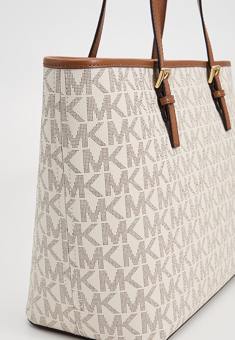 Grand sac fourre-tout en tissu crème texturé avec un motif de logo MK répétitif, agrémenté de poignées en cuir marron et de finitions en métal doré.