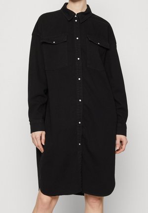 Black denim shirt dress featuring a collar, two chest pockets, and front button closure. Long sleeves and a relaxed fit design.