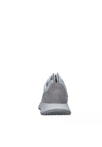 Sneaker bianco con tallone in suede grigio, parte superiore in rete e suola in gomma testurizzata. Presenta un logo sulla linguetta del tallone e un design elegante.