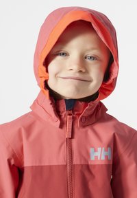 Chaqueta impermeable roja con capucha forrada de naranja, cierre frontal de cremallera y logo en contraste. Textura suave con un diseño ajustado para mayor calor.