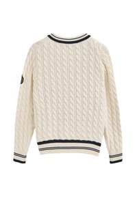 Kremowy sweter w splot warkoczowy z prążkowanym kołnierzem i dołem w czarno-białe paski. Posiada długie rękawy oraz niewielki detal z logo na lewym ramieniu.
