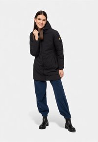 Giacca imbottita nera con cappuccio, chiusura frontale con zip e tasche laterali. Realizzata in materiale sintetico con una texture liscia e un design aderente.