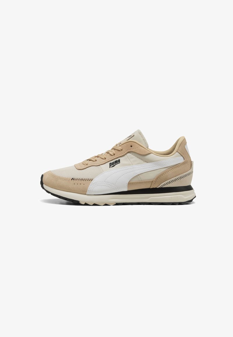 Zapatillas de malla y gamuza en beige y blanco con una suela gruesa, que cuentan con un acento negro y detalles de costura. Logotipo en el costado.