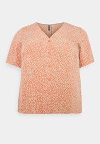 Blouse à manches courtes en tissu doux et texturé avec un fond crème et un motif abstrait corail, dotée d'un décolleté en V. Fermeture à cinq boutons.