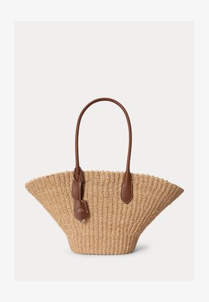 Sac fourre-tout en paille tissée de forme trapézoïdale large, avec des poignées en cuir marron et une petite étiquette en cuir suspendue portant la marque Polo.