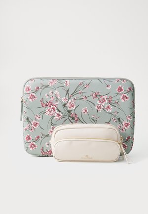 Mīksts zaļš portatīvā datora maciņš ar rozā ziedu apdruku, zeltīta rāvējslēdzējs. Mazāks bēšs maciņš ar zeltīdu aparatūru un zīmola logo. Abiem ir fakturētas virsmas.