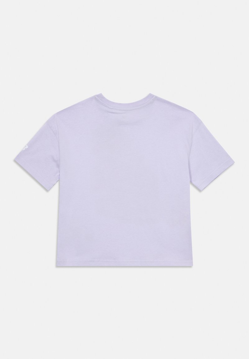 Camiseta corta de algodón lavanda con cuello redondo y mangas cortas. Presenta un pequeño diseño en la manga izquierda. Estilo limpio y minimalista.