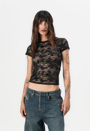 Crop top en dentelle noire avec des manches courtes et un col rond. Présente un motif rayé et un petit logo près de l'ourlet. Assortie avec un jean en denim bleu.
