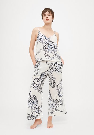 Lightweight cream pajama set featuring a leopard print in blue and black. The top has thin straps; the pants are wide-legged with pockets.
