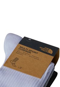 Calcetines de equipo multi-deportivo en gris claro con textura acanalada. Empaquetados con una etiqueta marrón que muestra los detalles del producto y el logotipo de la marca.