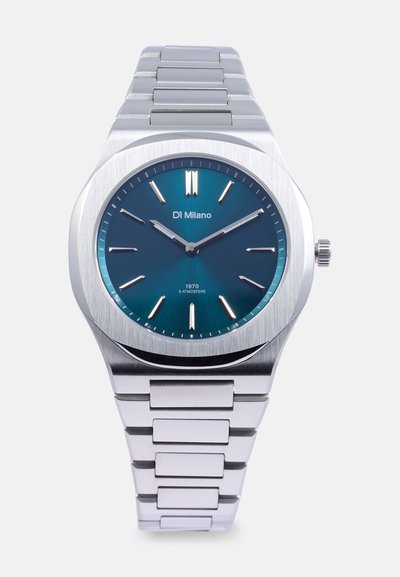 Montre en acier inoxydable avec une finition argentée brossée, cadran teal, deux aiguilles argentées et marqueurs d'heure. Elle est dotée d'un bracelet en métal à maillons.