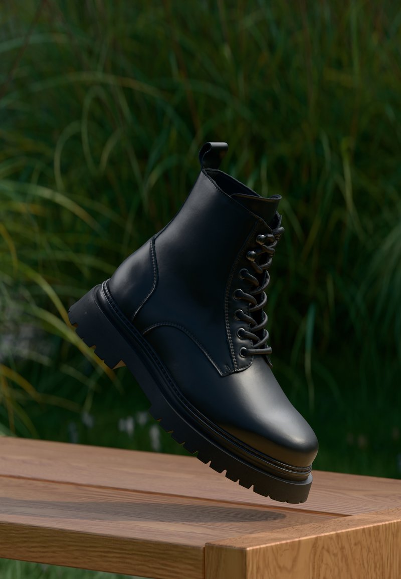 Μαύρη δερμάτινη μπότα αστραγάλου με στρογγυλή μύτη, κορδόνια μπροστά και παχύ οδοντωτό πάτο. Διαθέτει θηλιά στην επένδυση για εύκολη εφαρμογή.