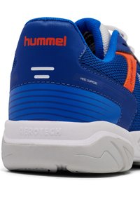 Scarpa sportiva blu con tomaia in rete texturizzata, supporto al tallone liscio, dettagli arancioni e suola bianca Aerotech con motivi antiscivolo.