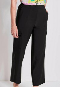 Zwarte cargobroek met een hoge taille, zij- en voorkruispockets, rechte snit en een soepele textuur, ontworpen voor comfort en functionaliteit.