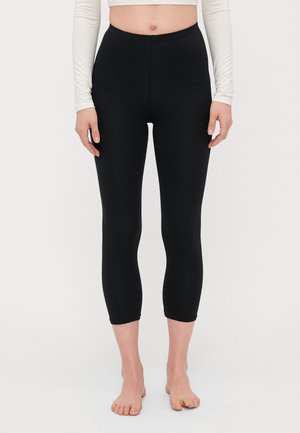 Svart leggings med høy midje, laget av elastisk stoff. Korte ben, glatt tekstur, og ingen synlige sømmer eller lommer.