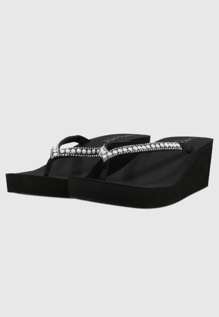 Black wedge sandals feature a smooth texture, crystal-embellished straps, and a contoured footbed for added comfort.