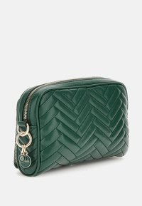 Grøn læder kosmetikpose med et vævet fiskebensmønster. Har en guldfarvet lynlås og et rundt logo-accent på siden. Kompakt og rektangulær form.