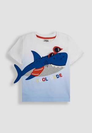 Hvid bomulds t-shirt med et blåt hajmotiv med røde detaljer, en ombre lys blå baggrund og teksten "COOL DUDE" i farverigt struktureret syning.