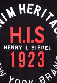 Černé bavlněné tričko s výrazným červeným a bílým textem: "H.I.S", "HENRY I. SIEGEL" a "1923" v kruhovém designu.
