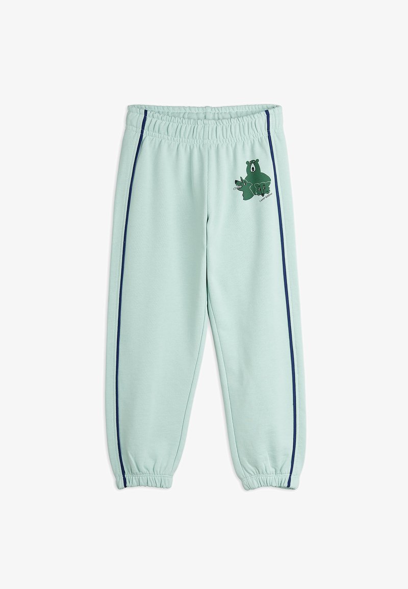 Pantaloni della tuta verde menta con vita elasticizzata, strisce laterali blu e una grafica di una rana e un orso sulla coscia sinistra. Tessuto morbido.